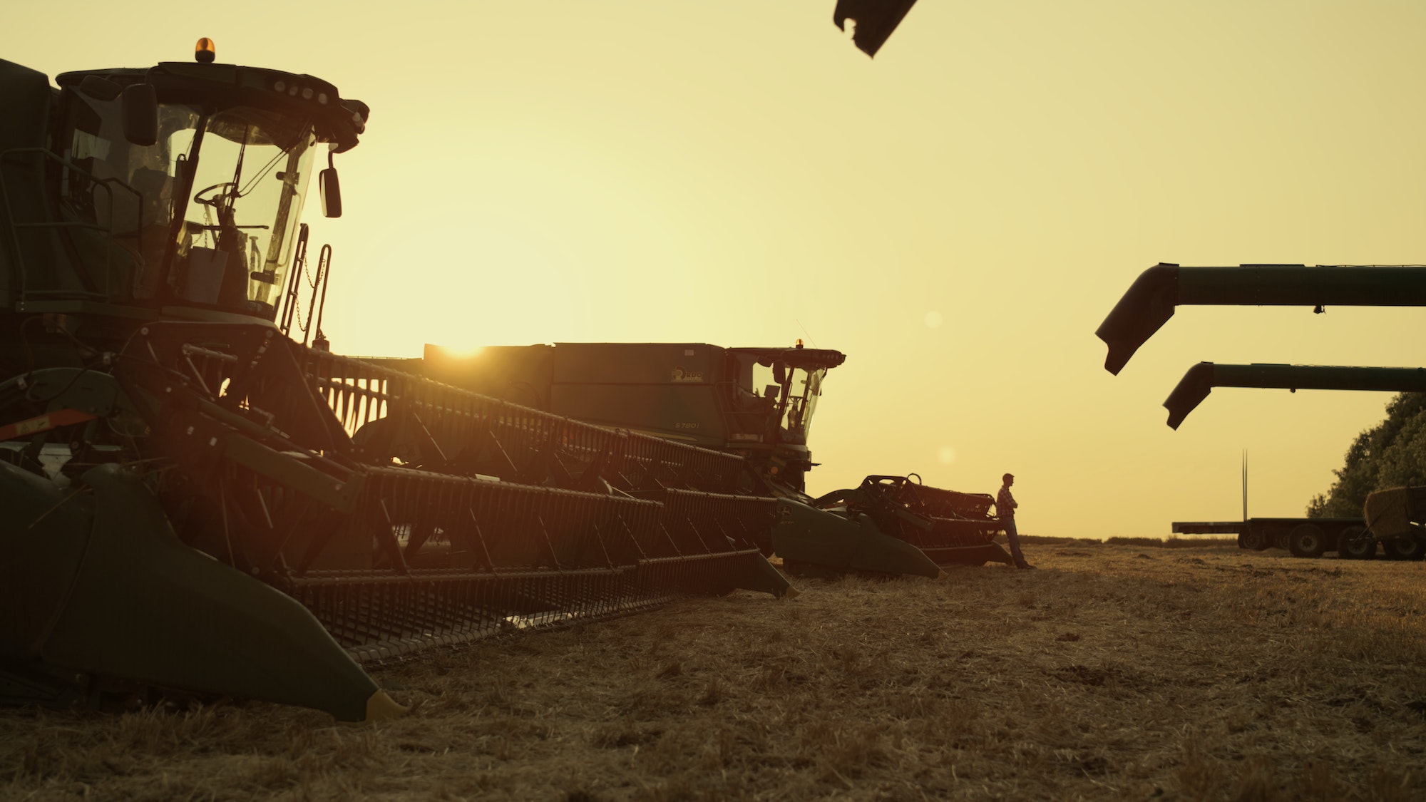 Machinery equipment silhouette at sunset wheat field farmland. Agro concept